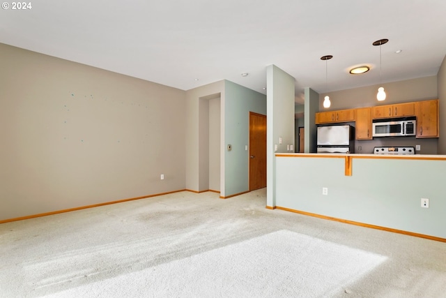 interior space featuring stainless steel appliances, hanging light fixtures, and light carpet