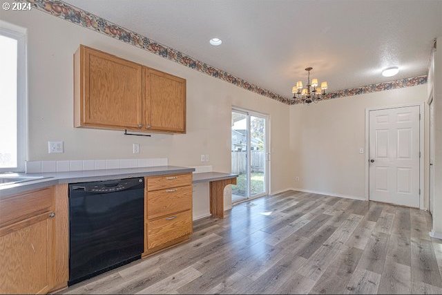 kitchen featuring an inviting chandelier, light hardwood / wood-style flooring, dishwasher, and decorative light fixtures