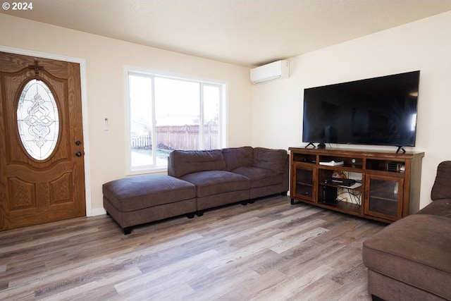 living room with a wall mounted AC and light wood-type flooring