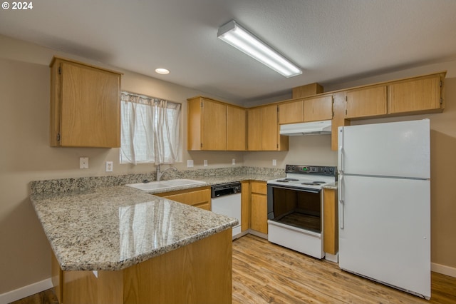 kitchen with kitchen peninsula, light wood-type flooring, and white appliances