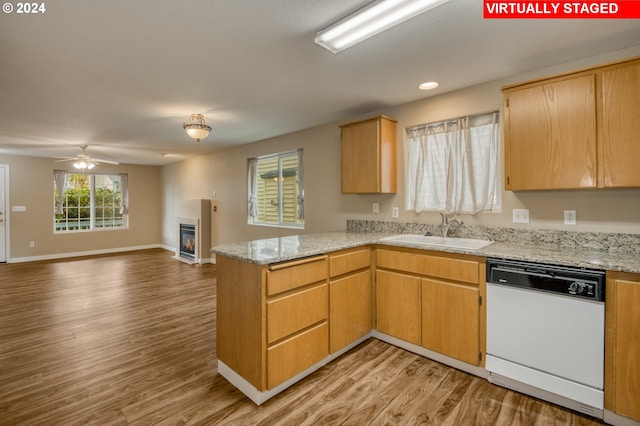 kitchen with light hardwood / wood-style flooring, kitchen peninsula, dishwasher, and sink