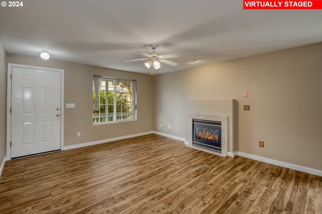 unfurnished living room featuring hardwood / wood-style flooring and ceiling fan