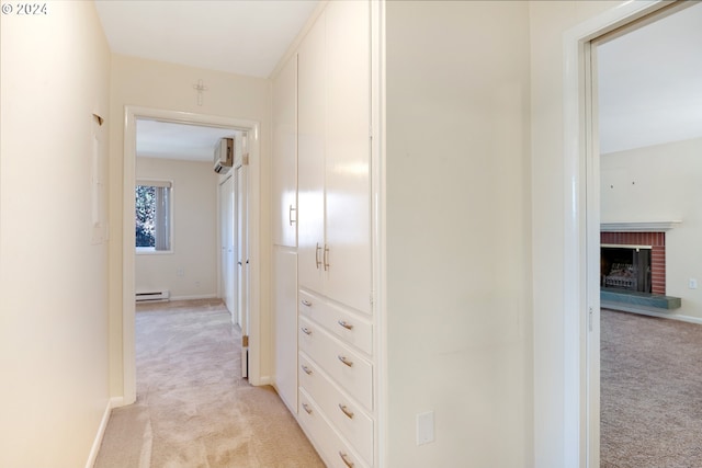 corridor featuring light carpet, a baseboard heating unit, and a wall mounted air conditioner