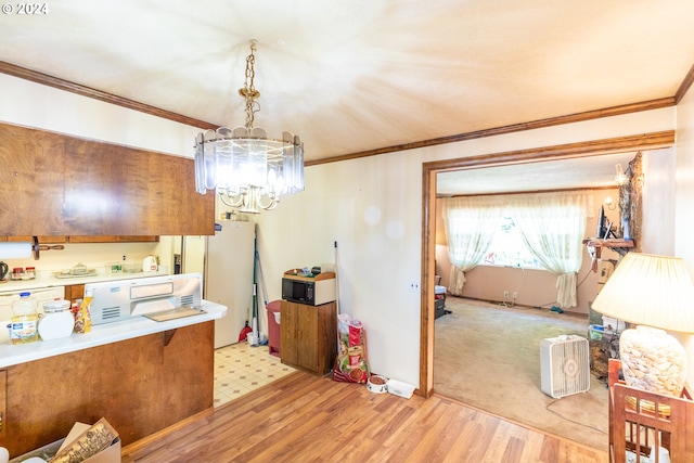 kitchen with ornamental molding, light wood-type flooring, decorative light fixtures, and a notable chandelier