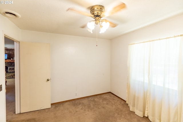 carpeted spare room featuring ceiling fan