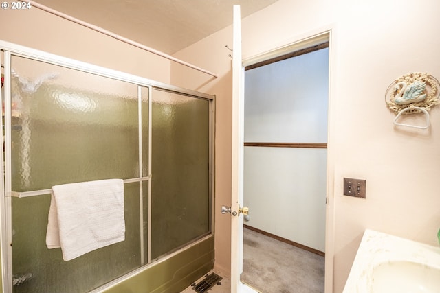 bathroom featuring shower / bath combination with glass door and sink