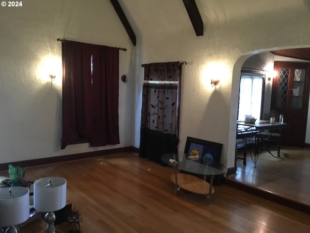 interior space with vaulted ceiling with beams and wood-type flooring