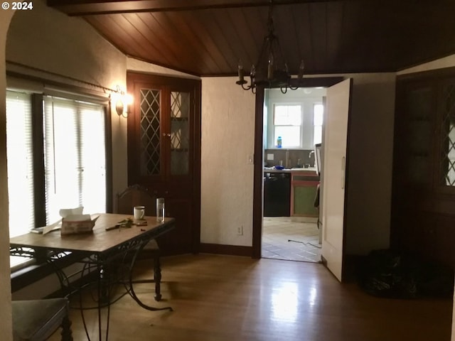 dining space featuring hardwood / wood-style floors, lofted ceiling with beams, wood ceiling, and a chandelier