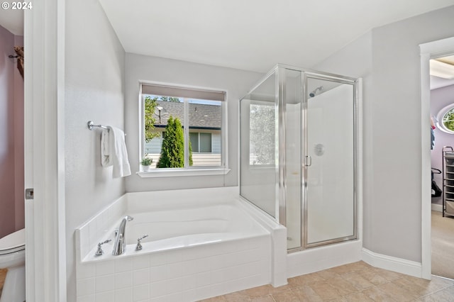 bathroom with tile patterned flooring, shower with separate bathtub, and toilet