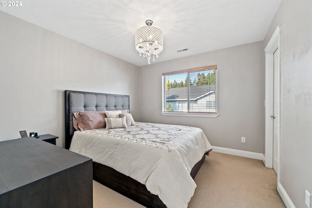 carpeted bedroom with a notable chandelier