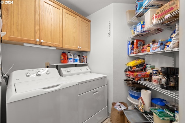 laundry area featuring separate washer and dryer and cabinets