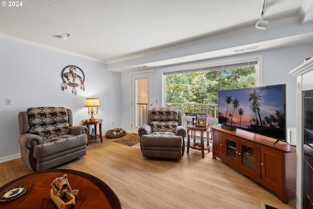 living room with light wood-type flooring, a textured ceiling, and ornamental molding