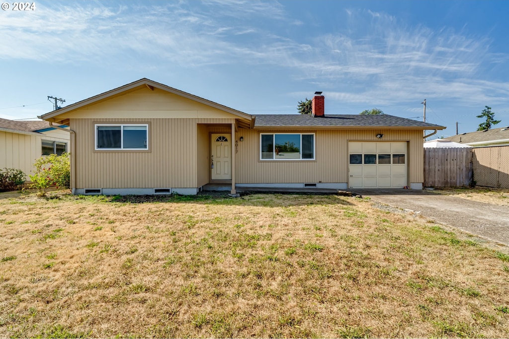 single story home with a garage and a front lawn