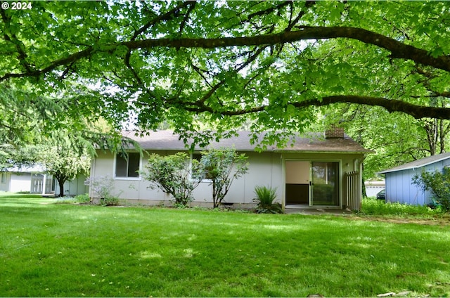 back of property featuring a lawn