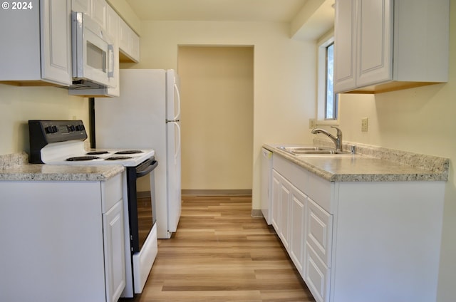 kitchen with white cabinets, white appliances, light hardwood / wood-style floors, and sink