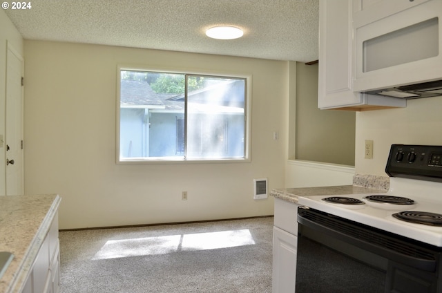 kitchen with white cabinets, light carpet, white appliances, and a textured ceiling