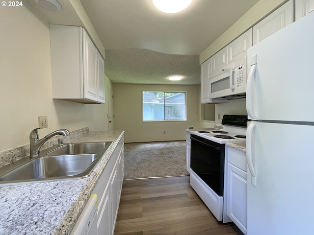 kitchen featuring white cabinets, white appliances, sink, and hardwood / wood-style floors