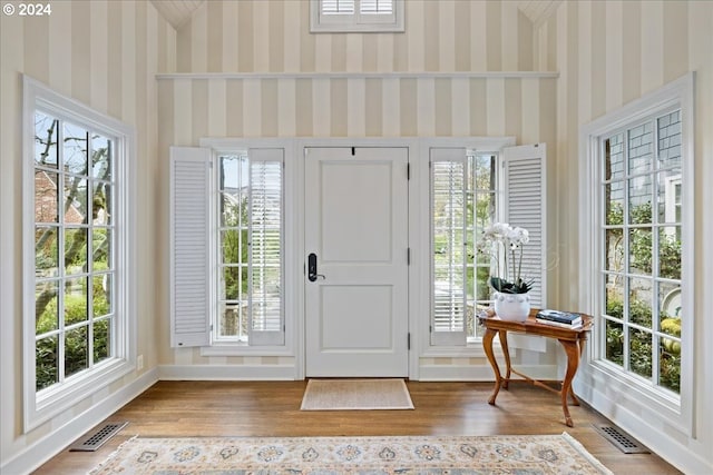 entryway featuring a towering ceiling and wood-type flooring