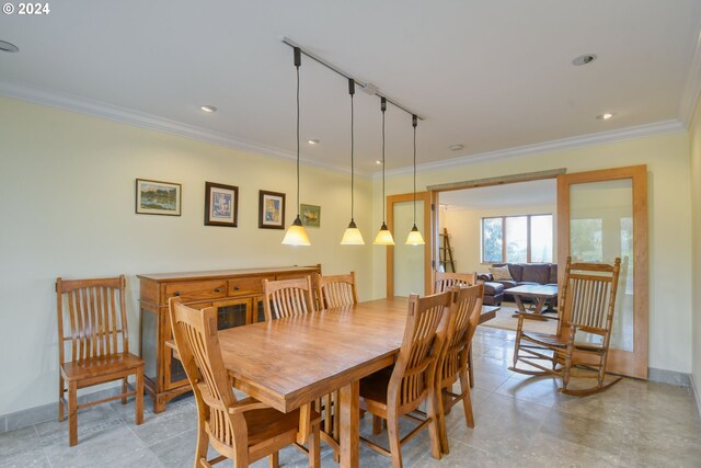 dining space with tile floors and crown molding