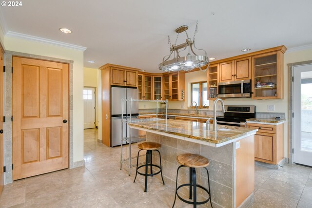 kitchen featuring appliances with stainless steel finishes, ornamental molding, light tile flooring, and an island with sink