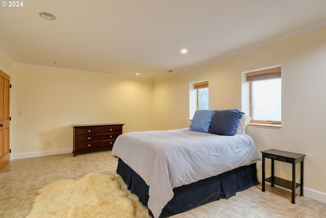 bedroom with light tile floors and crown molding