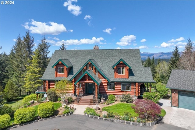 log cabin featuring covered porch and a garage