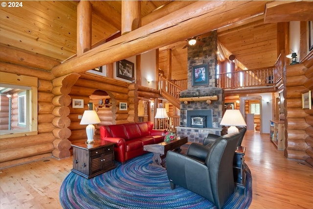 living room featuring a stone fireplace, high vaulted ceiling, wooden ceiling, hardwood / wood-style flooring, and rustic walls