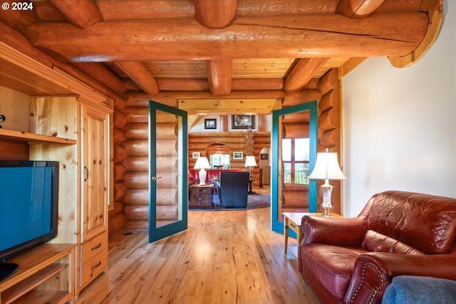 living room featuring hardwood / wood-style flooring, log walls, and beam ceiling