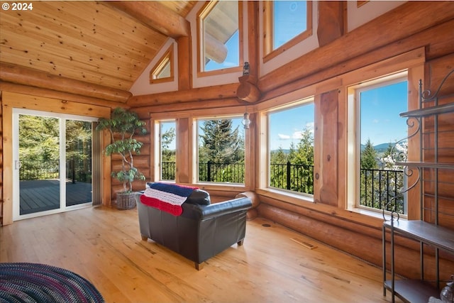 sunroom / solarium featuring wood ceiling, a healthy amount of sunlight, and vaulted ceiling