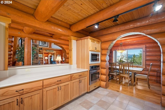 kitchen with appliances with stainless steel finishes, wooden ceiling, rail lighting, and rustic walls