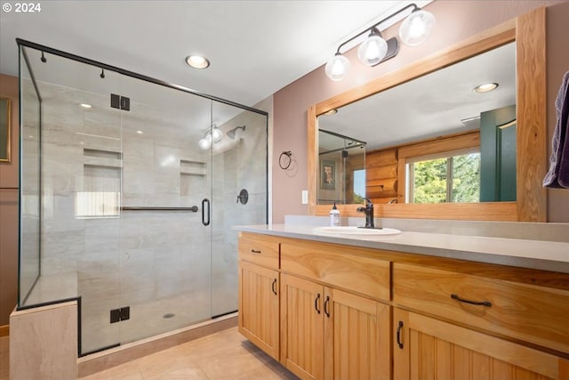 bathroom with an enclosed shower, vanity, and tile floors