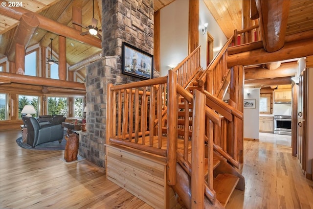 stairs featuring high vaulted ceiling, wooden ceiling, light hardwood / wood-style floors, and ceiling fan