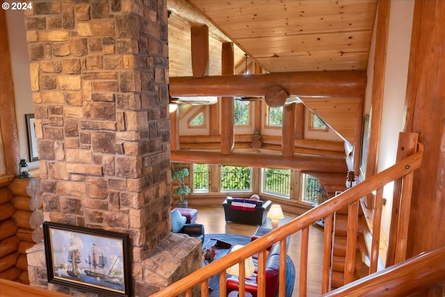 staircase with wood-type flooring, wood ceiling, vaulted ceiling, and log walls