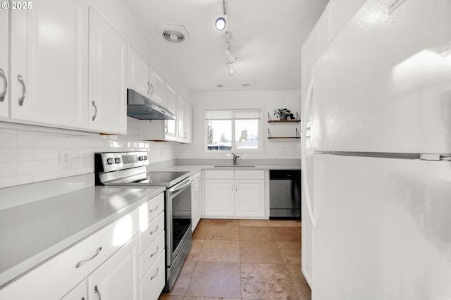 kitchen featuring stainless steel appliances, light tile patterned floors, decorative backsplash, sink, and white cabinetry