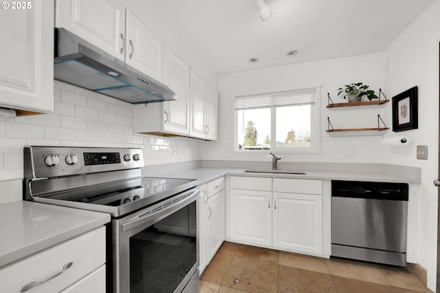 kitchen featuring white cabinets, appliances with stainless steel finishes, decorative backsplash, and sink