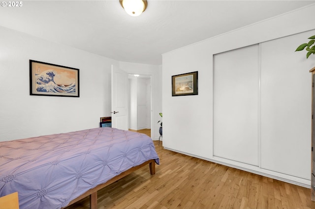 bedroom with light wood-type flooring and a closet