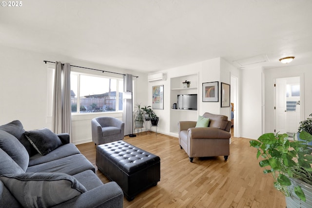 living room with a wall mounted AC, built in shelves, and wood-type flooring