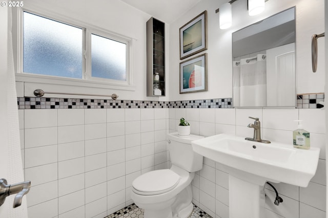 bathroom featuring tile walls, toilet, a shower with curtain, and tile patterned floors