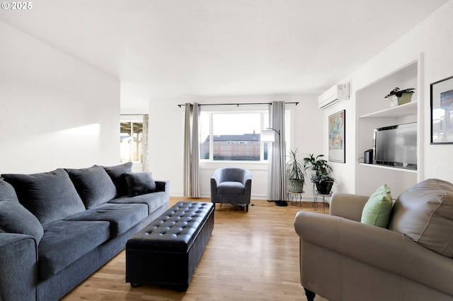 living room featuring light hardwood / wood-style floors and a wall mounted AC