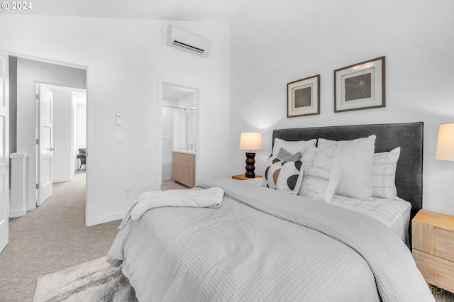 bedroom featuring a wall unit AC, lofted ceiling, light carpet, and ensuite bath