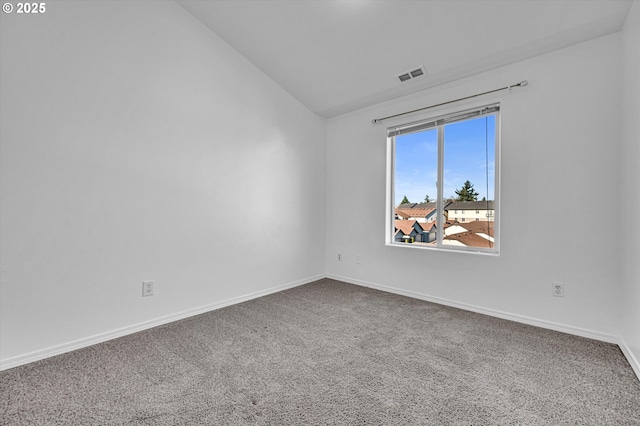 spare room featuring lofted ceiling and carpet