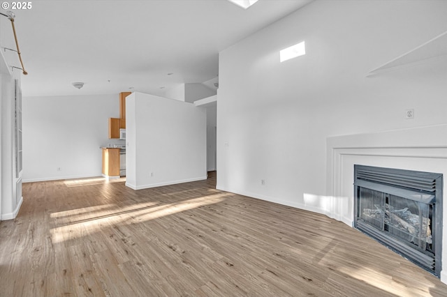 unfurnished living room with lofted ceiling and light hardwood / wood-style flooring