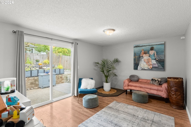 sitting room with hardwood / wood-style flooring and a textured ceiling