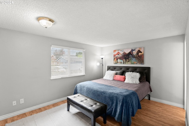 bedroom with wood-type flooring and a textured ceiling