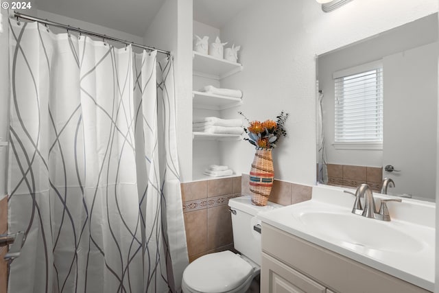 bathroom featuring vanity, toilet, and tile walls