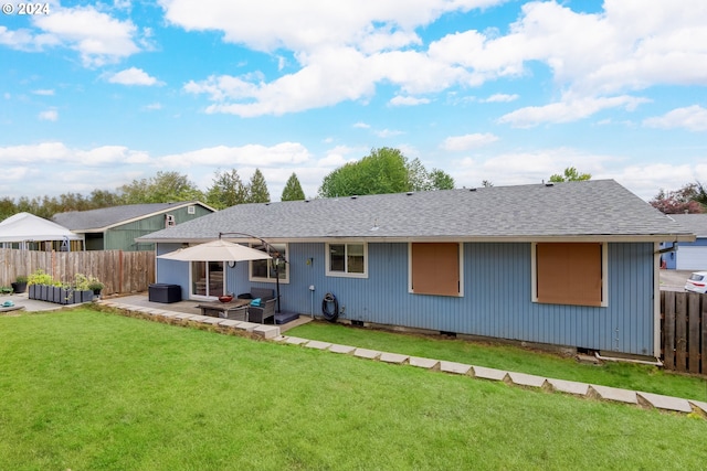 rear view of property with a yard and a patio area