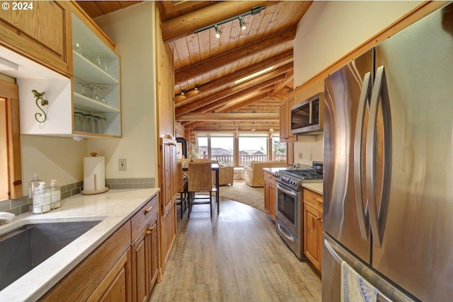 kitchen with wood ceiling, light hardwood / wood-style flooring, track lighting, stainless steel appliances, and lofted ceiling with beams