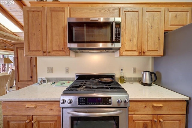 kitchen featuring appliances with stainless steel finishes, beamed ceiling, light stone countertops, and wood ceiling