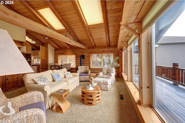 living room featuring wooden walls, vaulted ceiling with skylight, and wooden ceiling