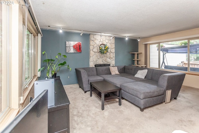 living room featuring a textured ceiling, light colored carpet, and track lighting